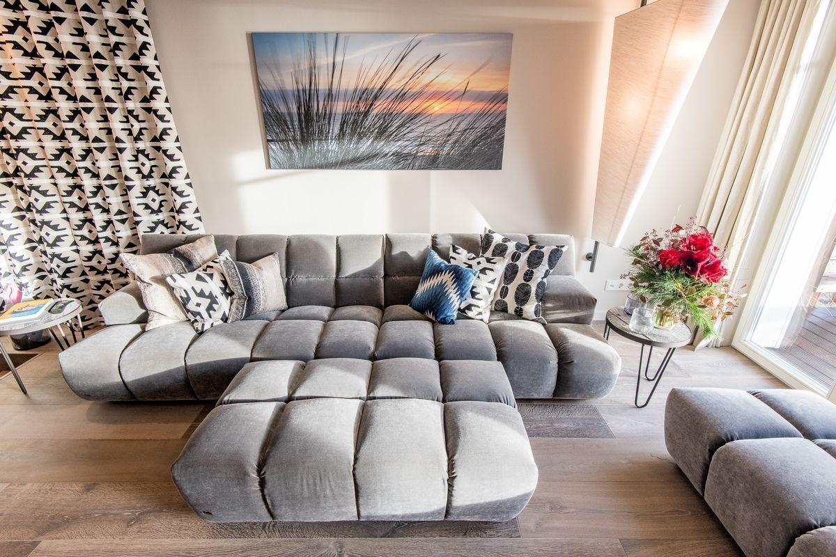 Großer grauer Sofa-Bereich mit Kissen und Wandbild