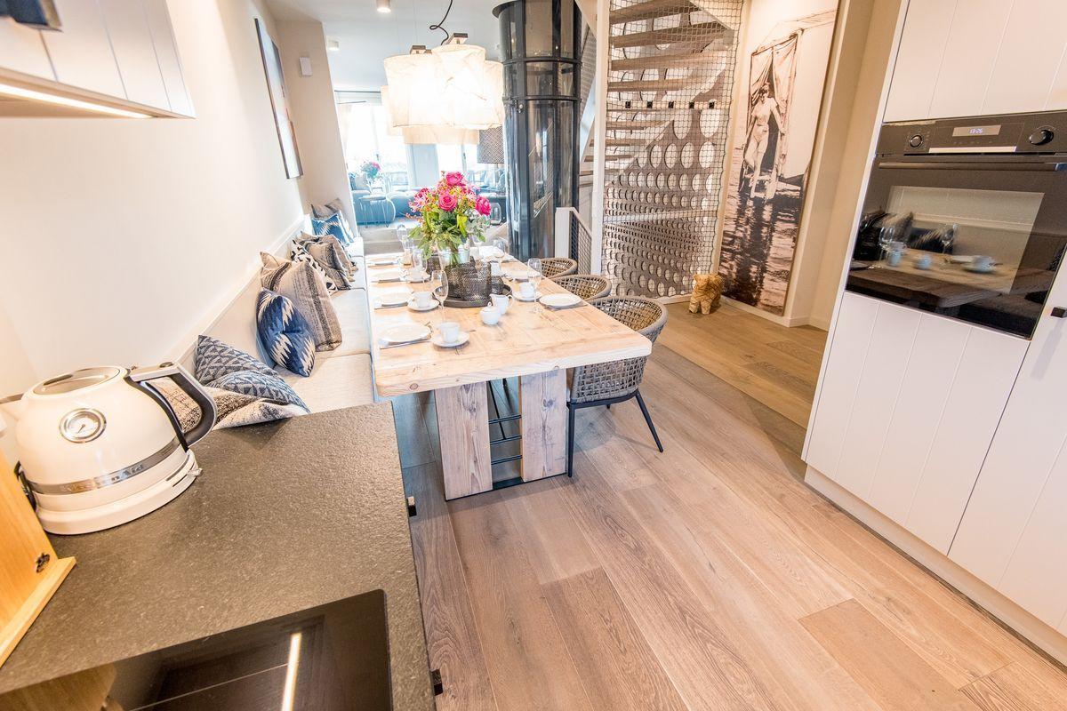 Essbereich mit Holztisch, Sitzbank und Küchenzeile.