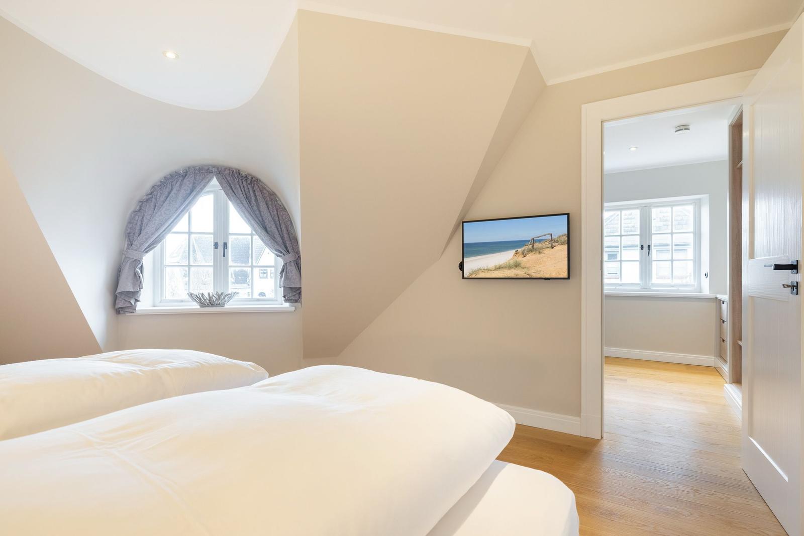 Schlafzimmer mit Dachschräge, Fenster und Fernseher