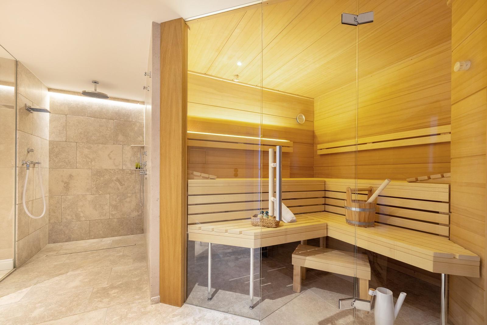 Sauna mit Holzbank und Dusche im Anschluss