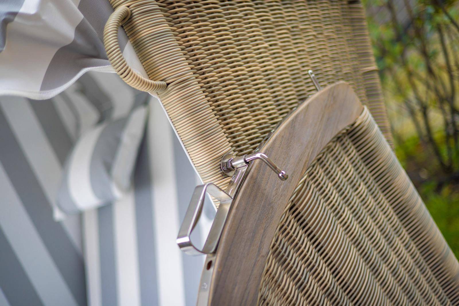 Wicker-Stuhl mit Holzrahmen und Metallbeschlägen im Freien