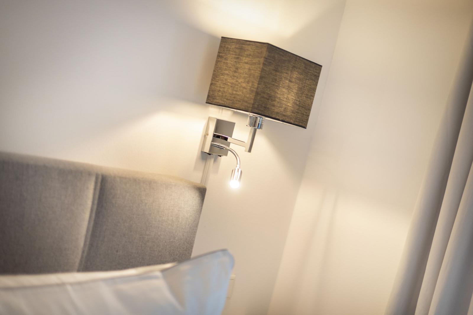 Bettkopfteil mit Wandlampe und Lampenschirm