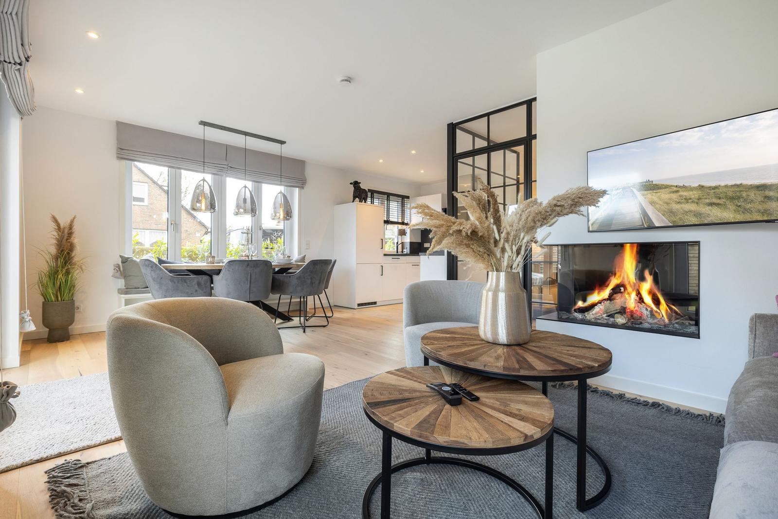 Wohnzimmer mit Kamin, Esstisch und moderner Einrichtung.