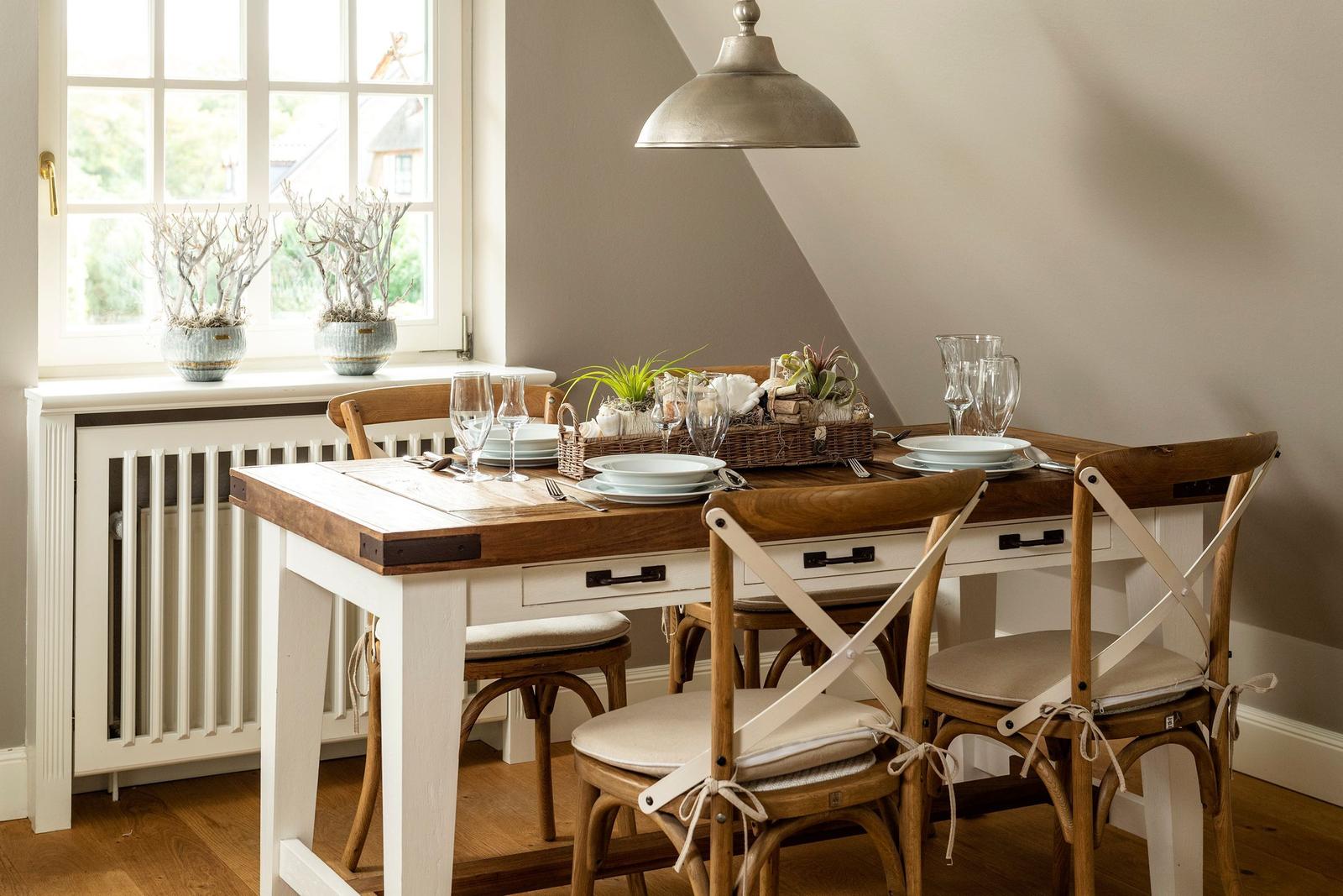 Dining table with four chairs and window view.