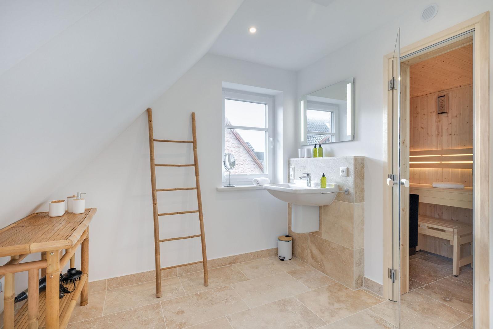 Badezimmer mit Dusche, Waschbecken und Sauna.