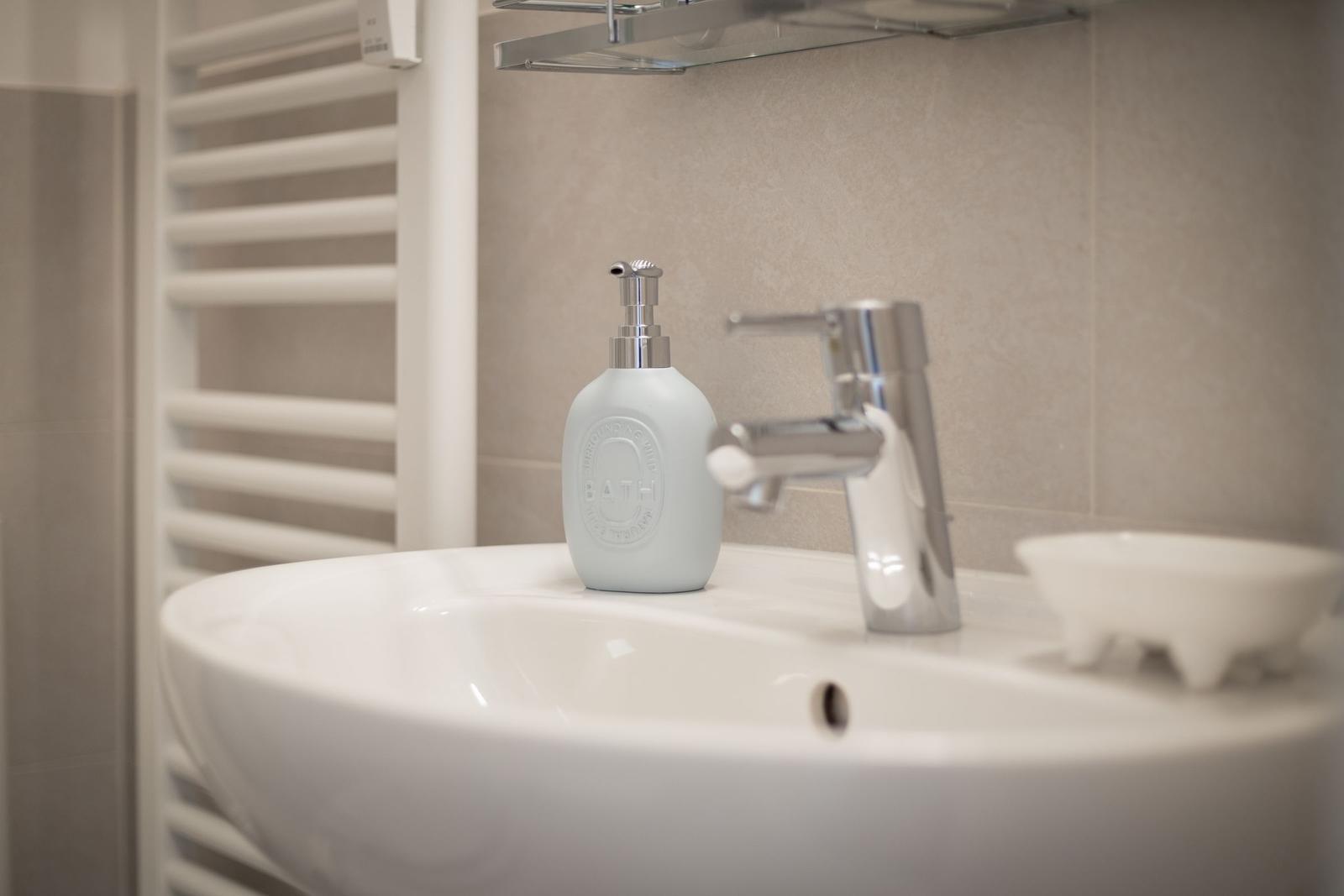 Waschbecken mit Seifenspender und Wasserhahn