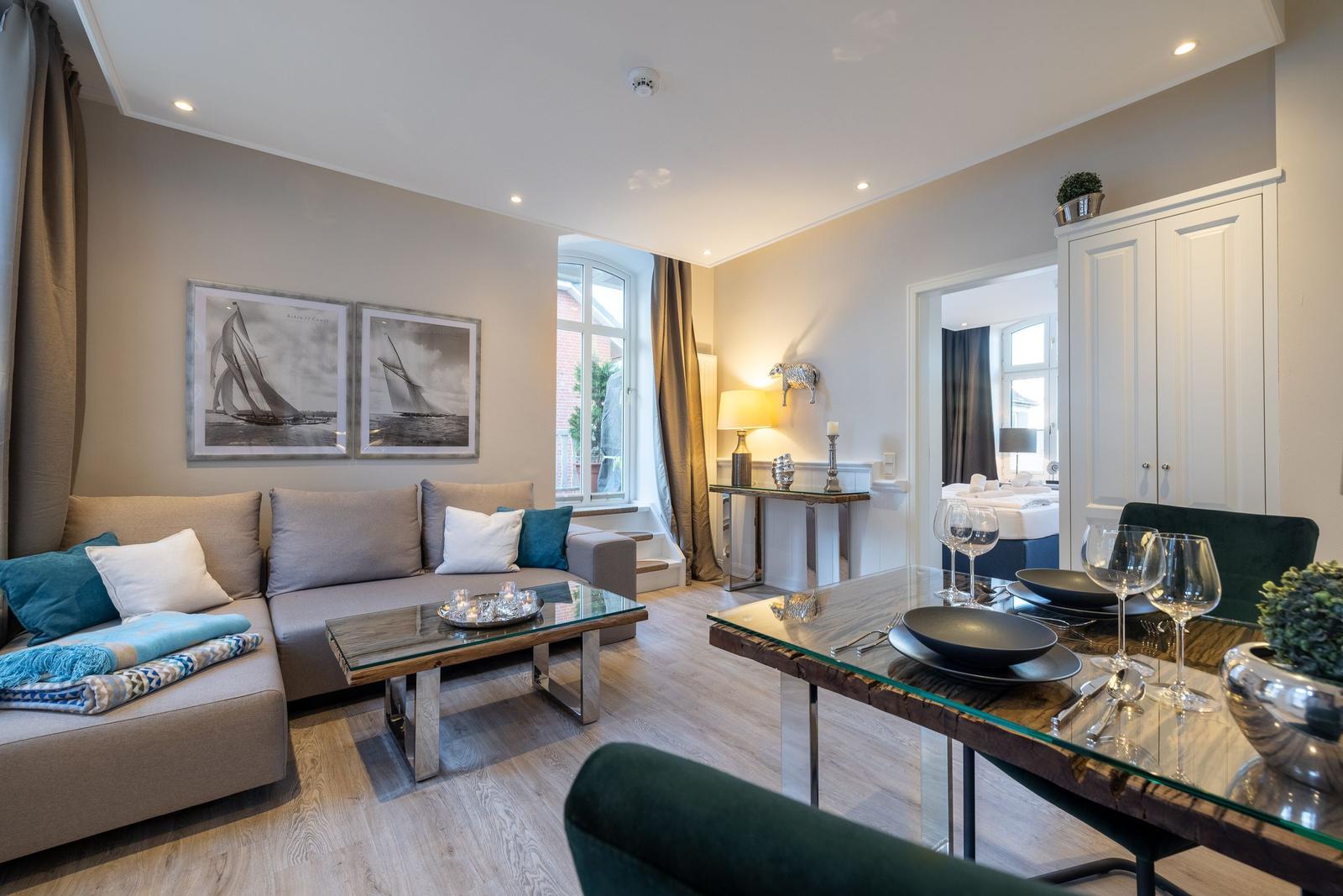 Wohn- und Essbereich mit Sofa, Tisch und Blick in Schlafzimmer