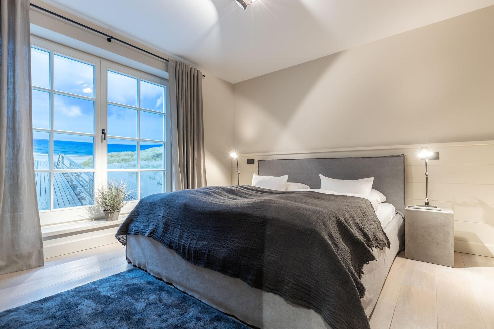 Schlafzimmer mit Blick auf Strand und Meer.