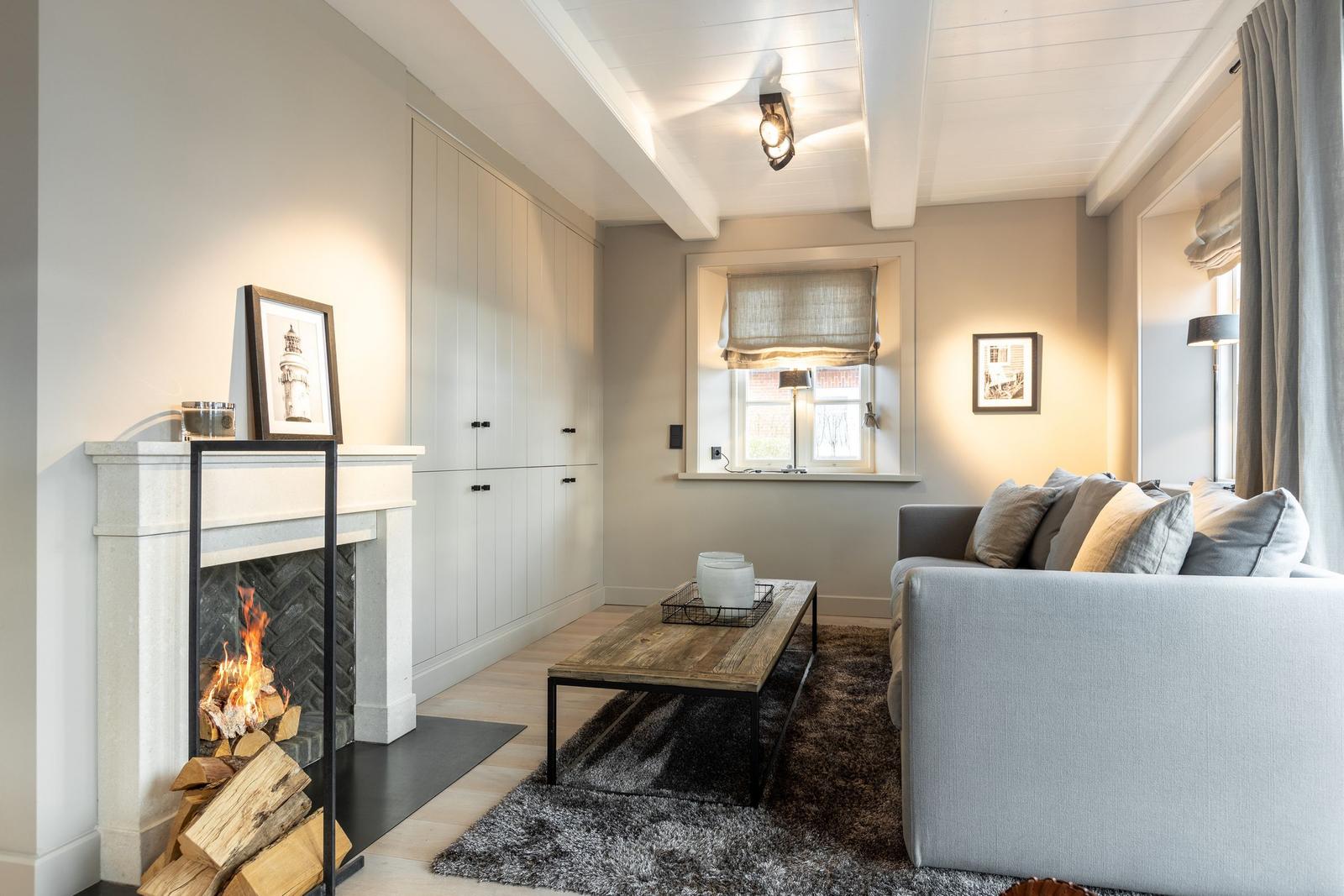 Wohnzimmer mit Kamin, Sofa und Holztisch