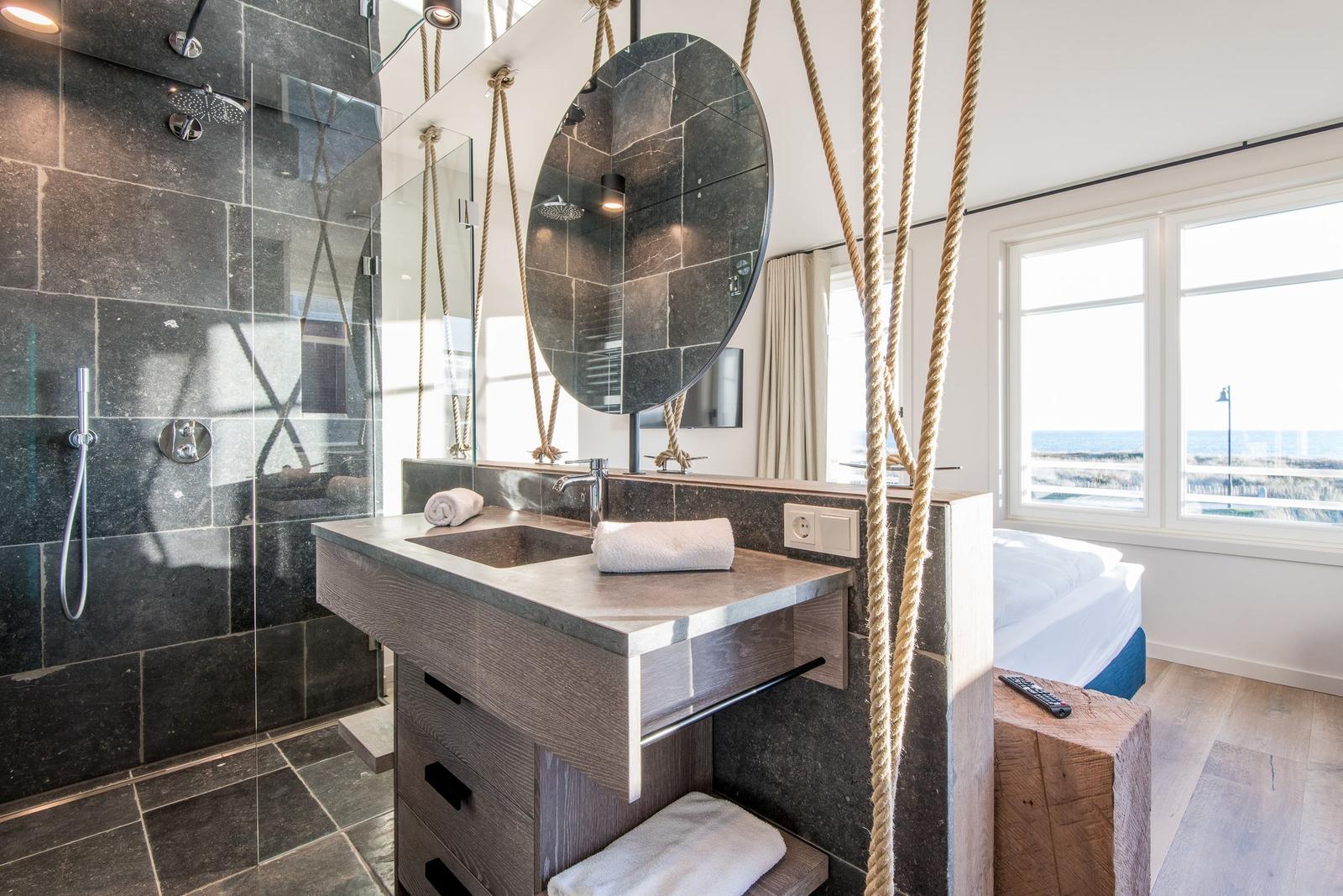 Bad mit Dusche, Waschbecken und Blick aufs Meer