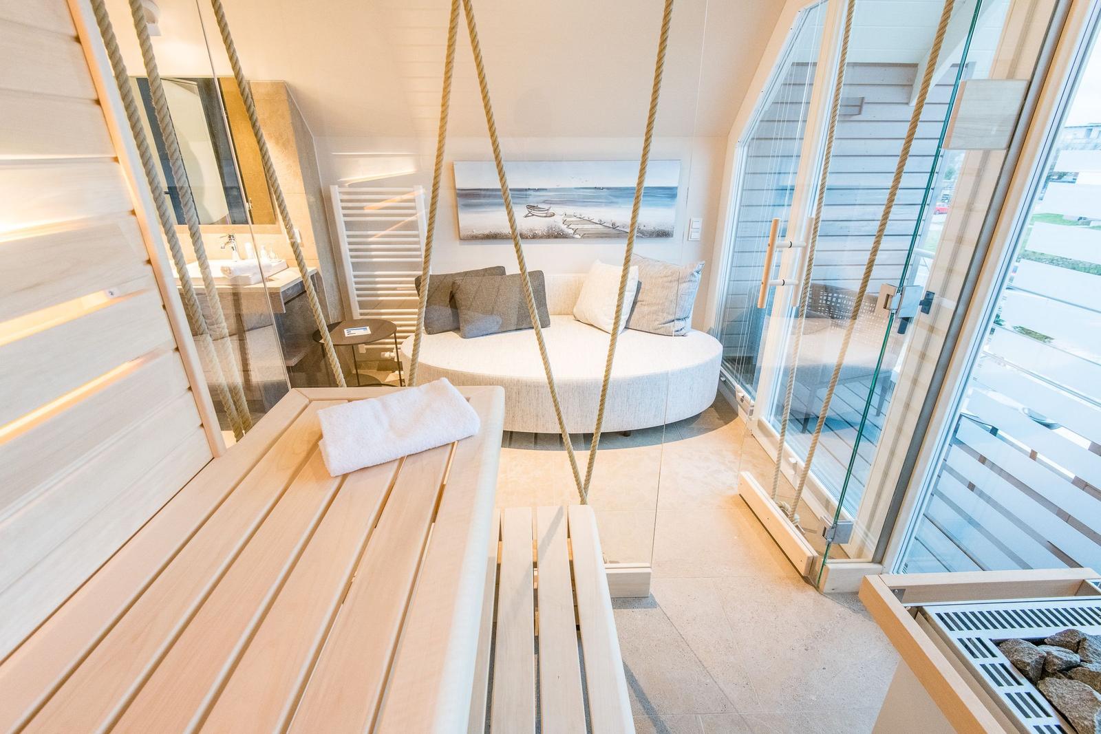 Sauna mit Holzbank, Seeblick und Badewanne im Hintergrund