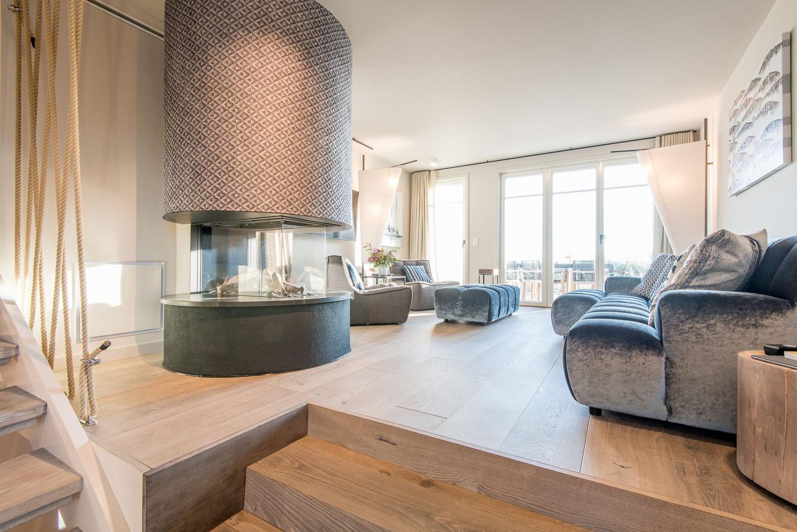 Wohnbereich mit Kamin, Sofa und Terrasse
