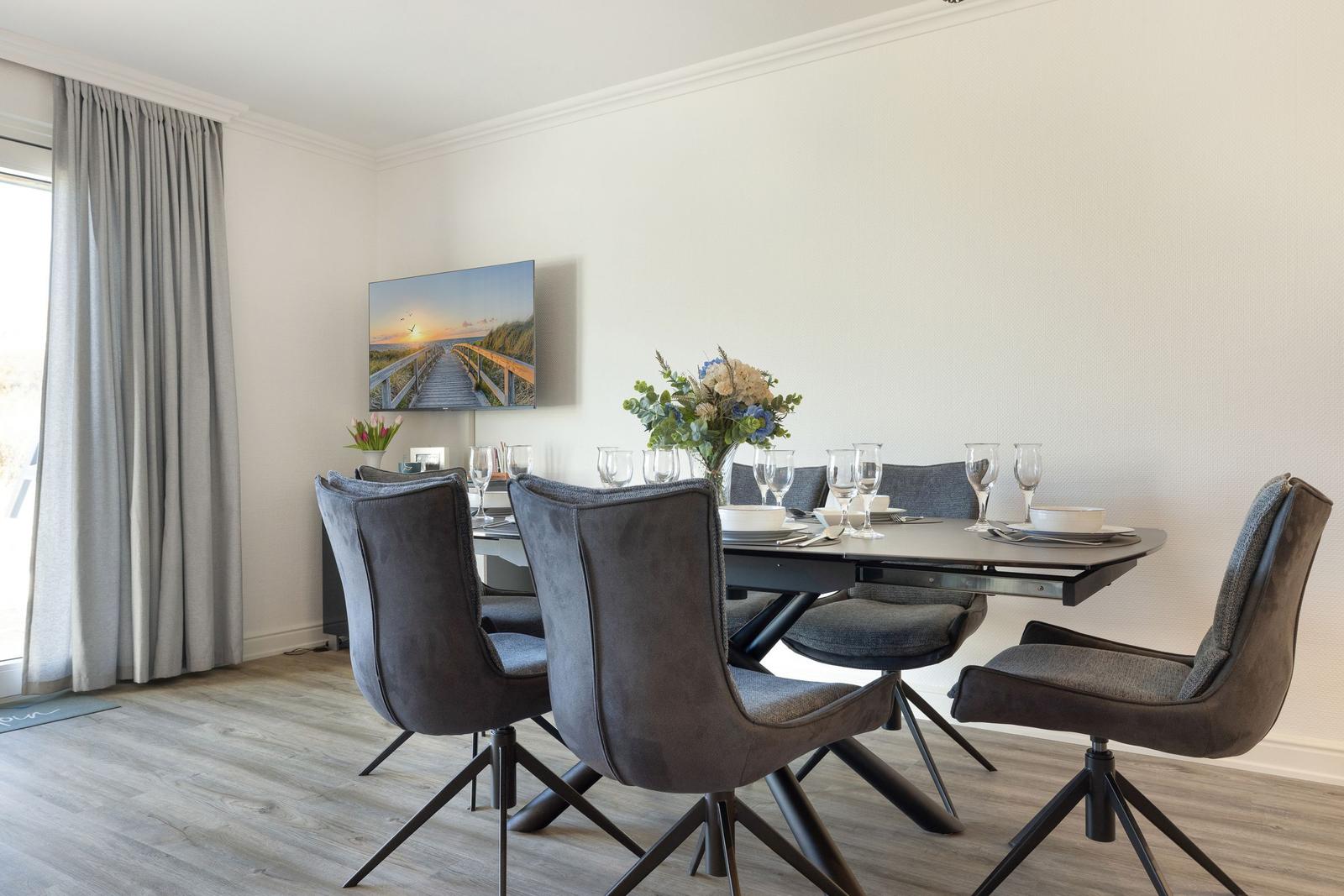 Dining room with table, chairs, and wall picture.