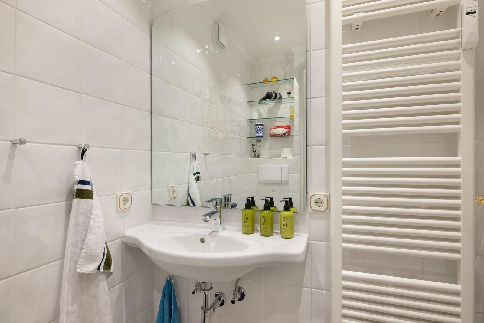 Bathroom with sink, mirror, and heater