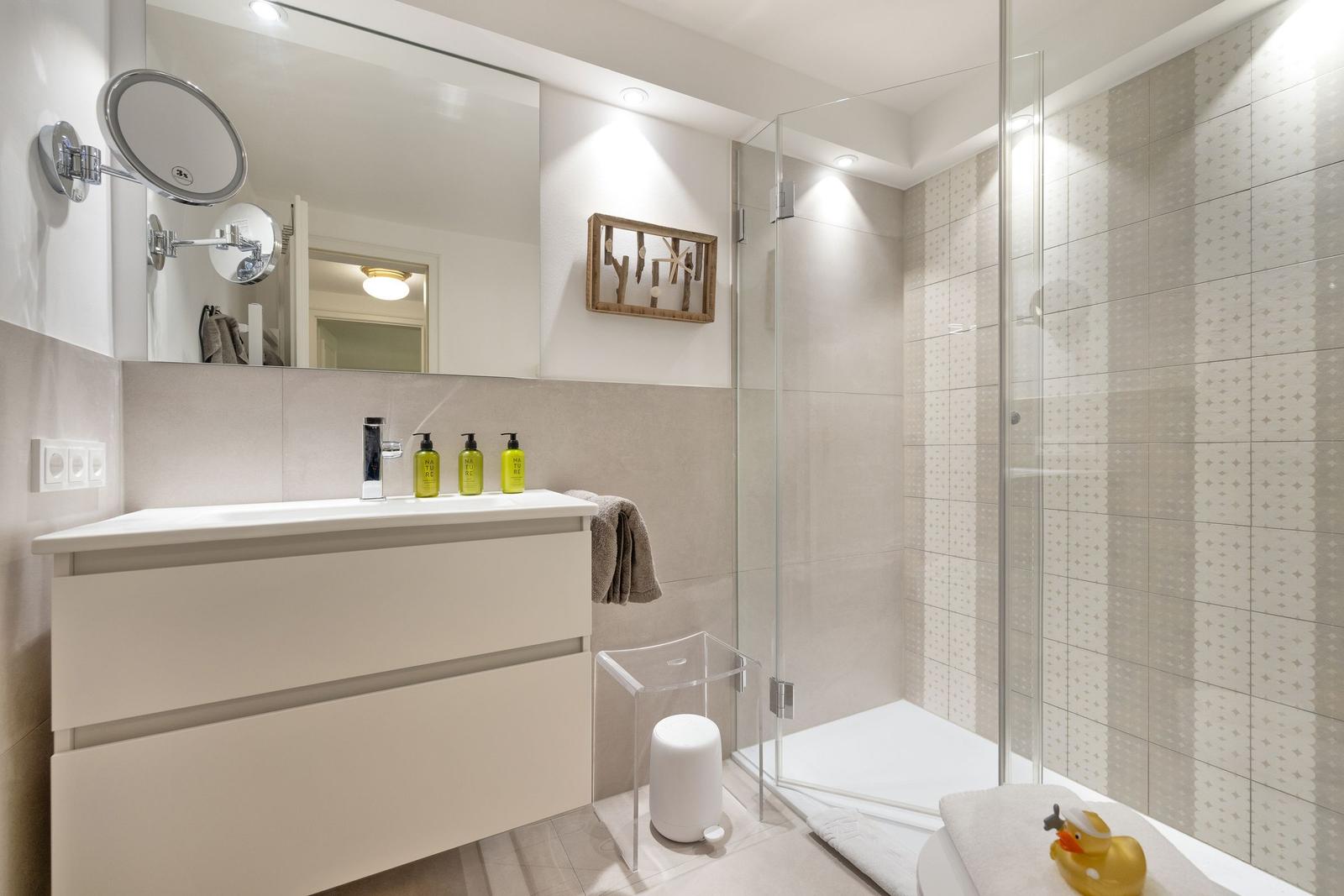 Bathroom with shower, sink, and mirror