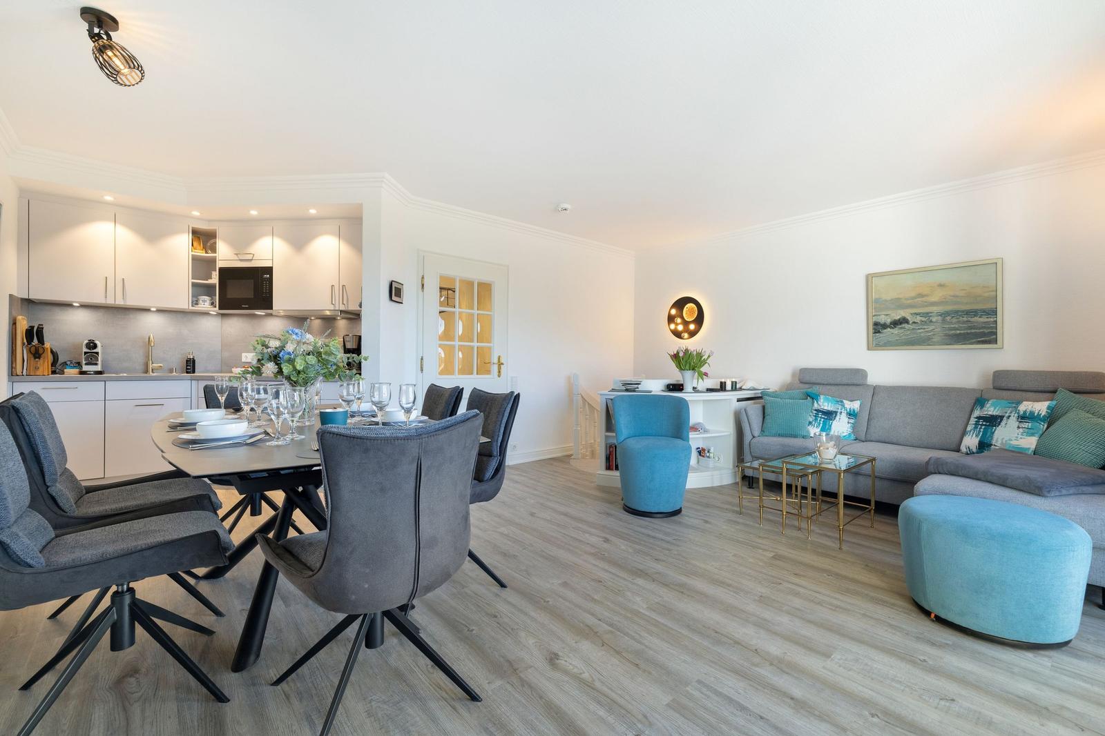 Living and dining area with kitchenette, sofa, and chairs.