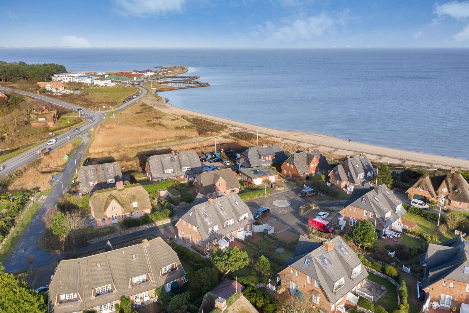 Häuser am Strand mit Blick aufs Meer und eine Straße.