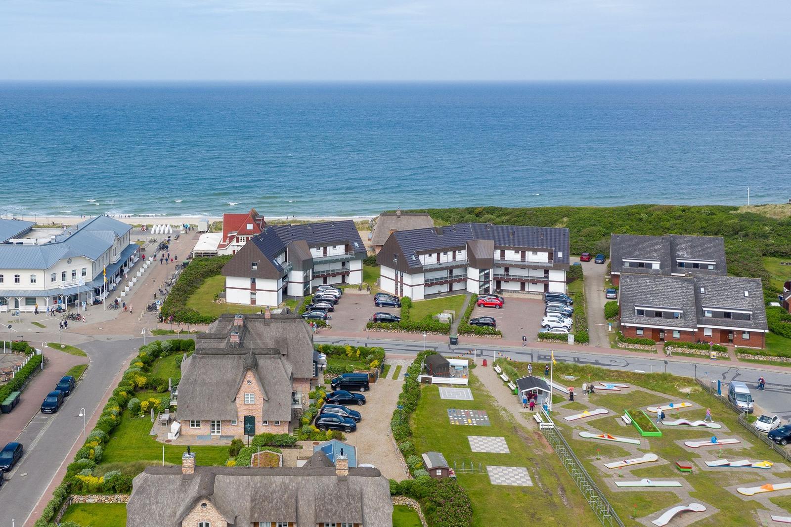 Strandnahe Ferienhäuser mit Parkplatz und Minigolfanlage.