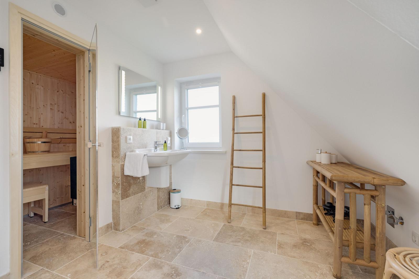 Badezimmer mit Dusche, Waschbecken und Sauna im Anbau.
