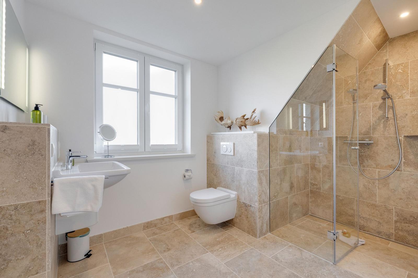 Badezimmer mit Dusche, Toilette und Waschbecken