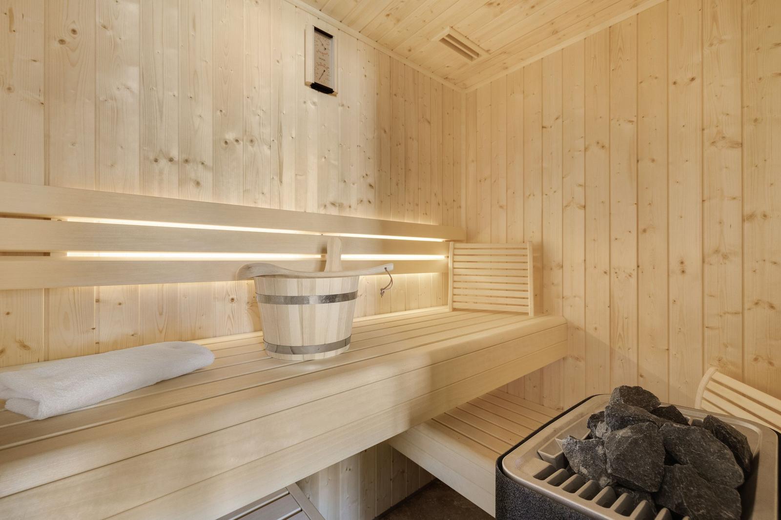 Sauna mit Holzbank, Eimer und Steine