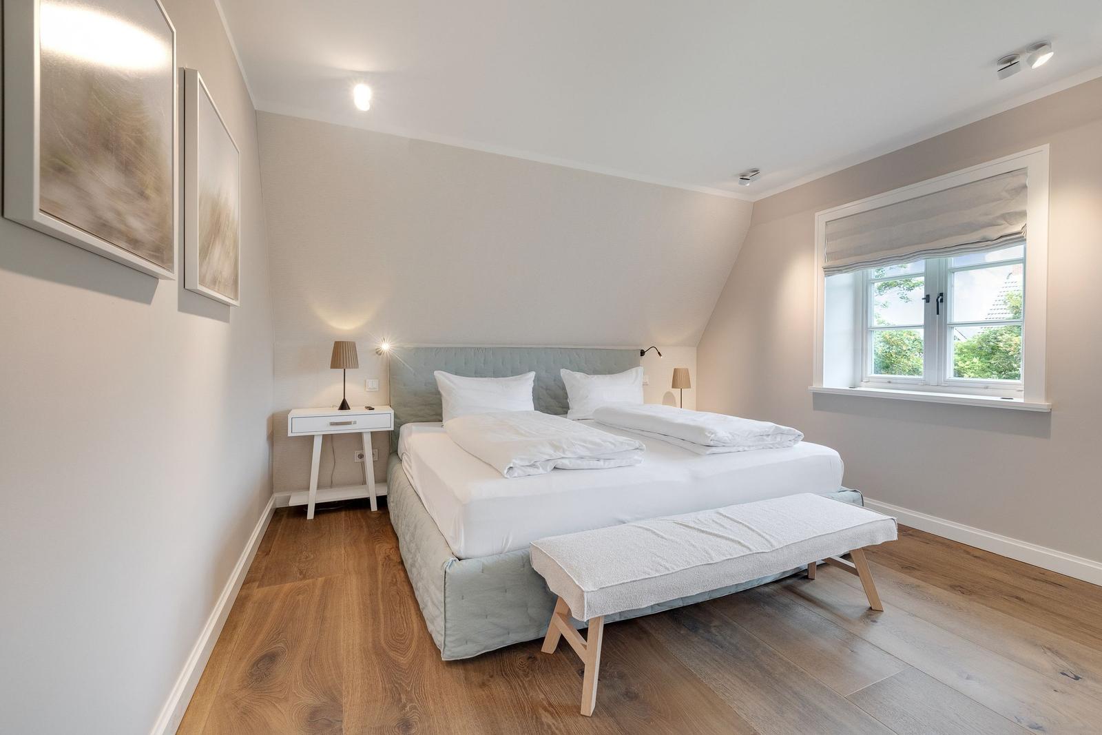 Bedroom with double bed, wooden floor, and window
