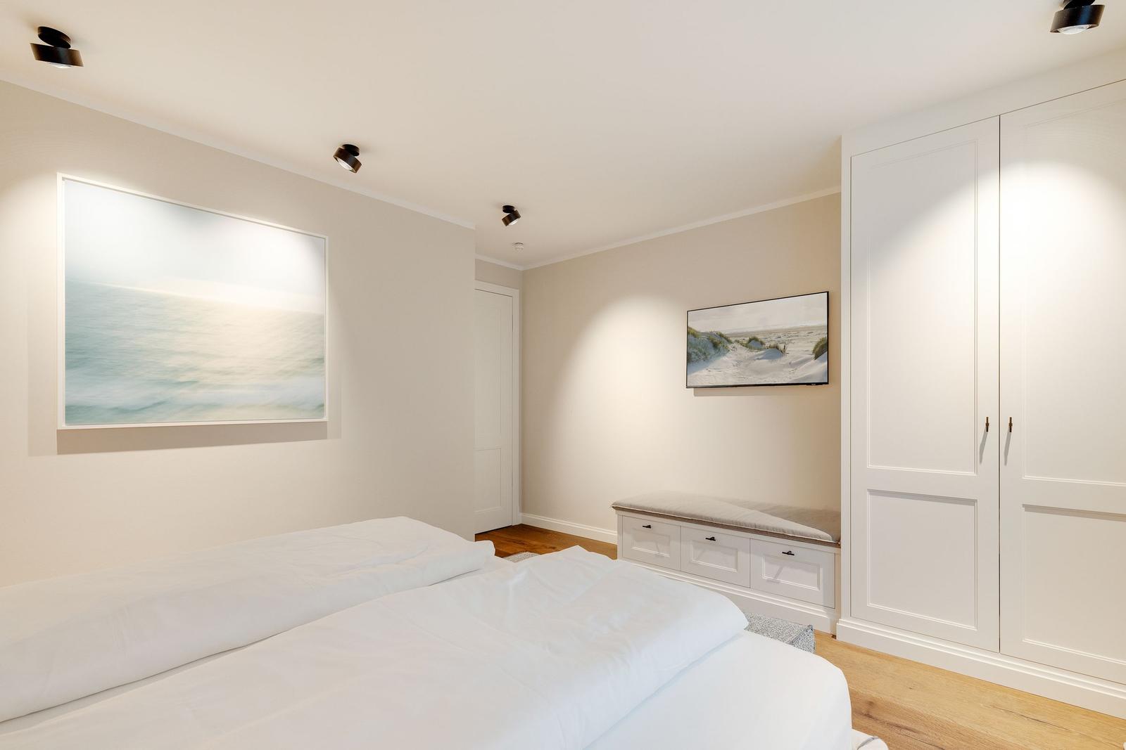 Bedroom with bed, wardrobe, and wall pictures