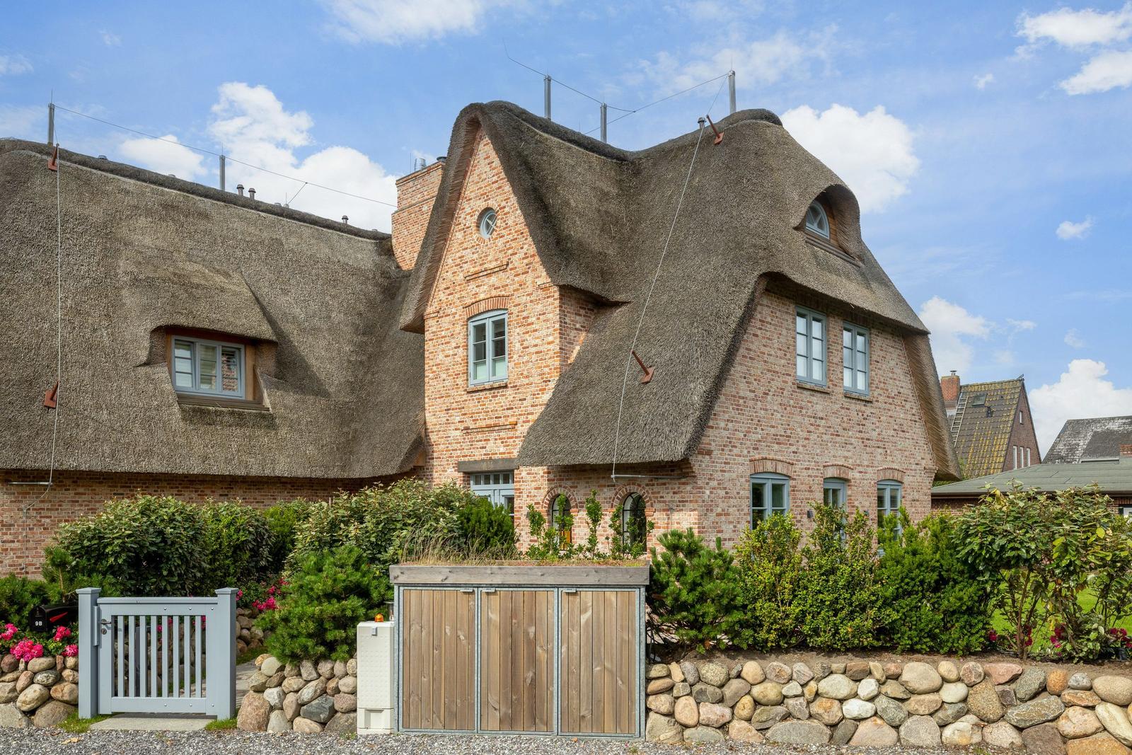 House with thatched roof and stone wall enclosure
