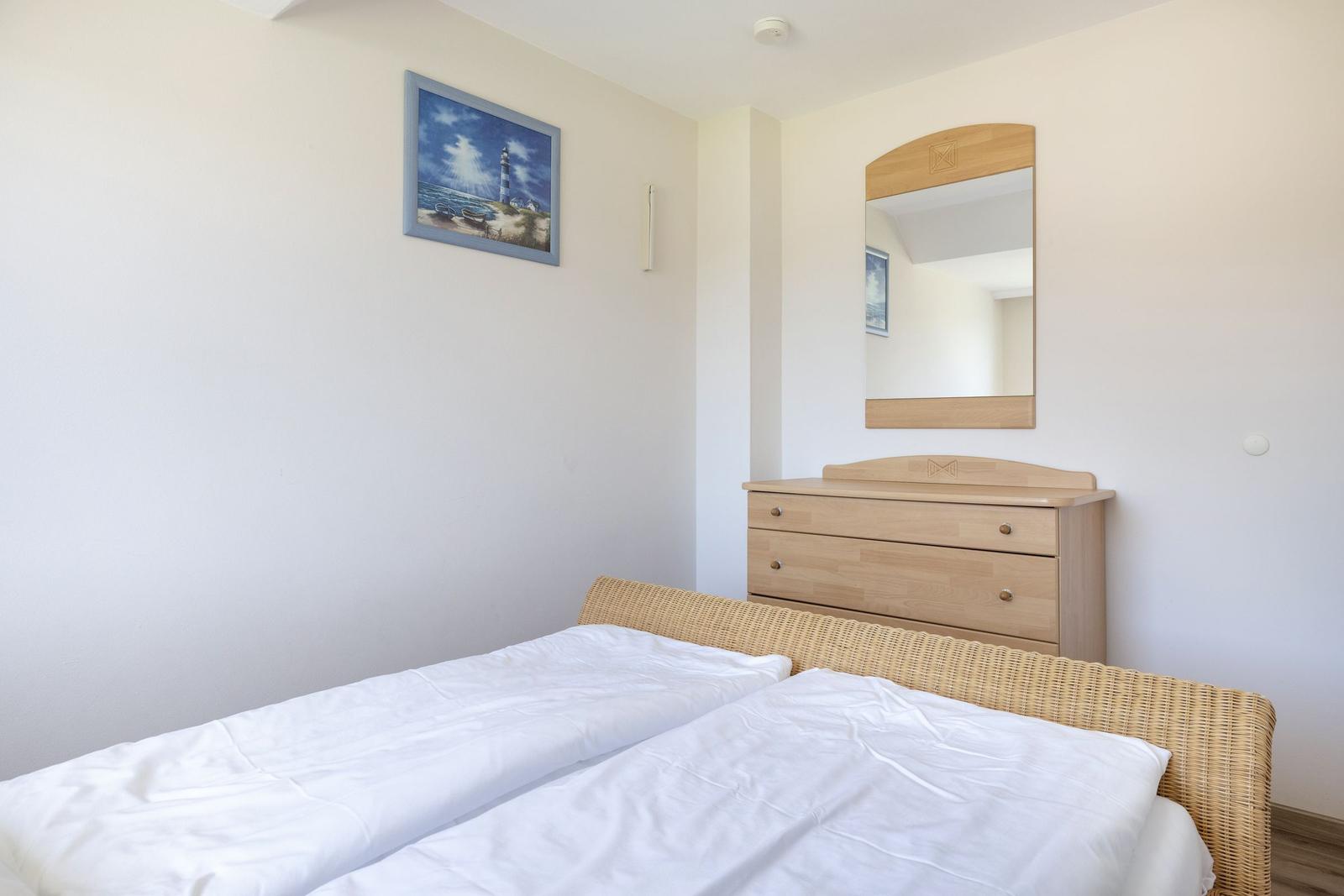 Schlafzimmer mit Doppelbett, Schrank und Wandbild