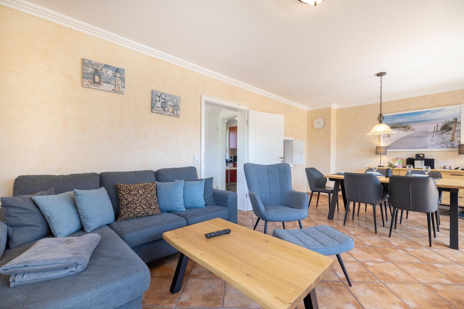 Wohn- und Essbereich mit Sofa, Stühlen und Holztisch.