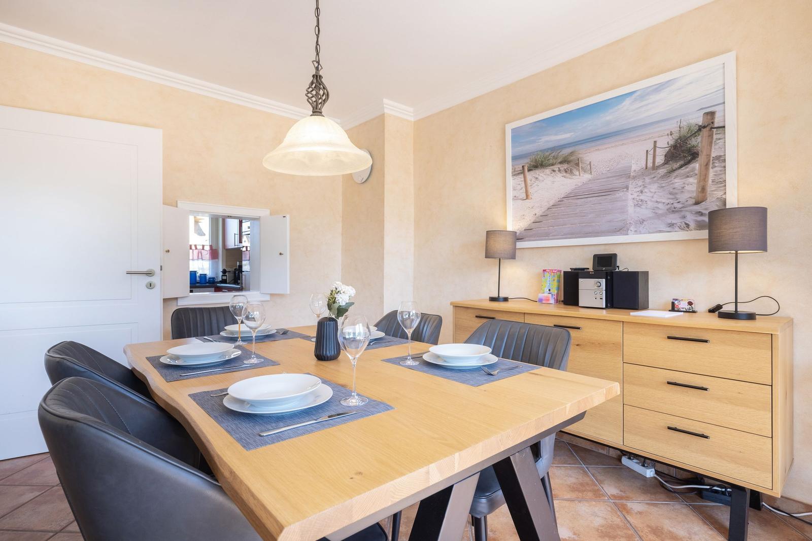 Esstisch mit sechs Stühlen, Wandbild und Sideboard im Esszimmer.