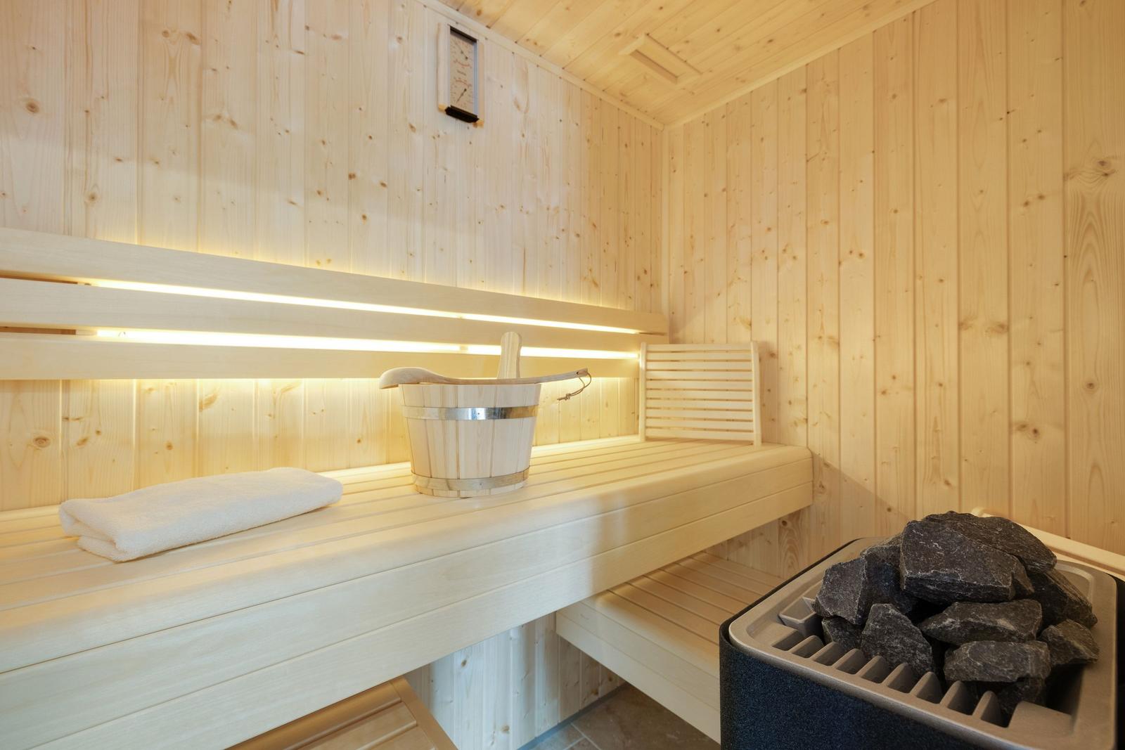 Sauna mit Holzbänken, Waschbecken und Steinen