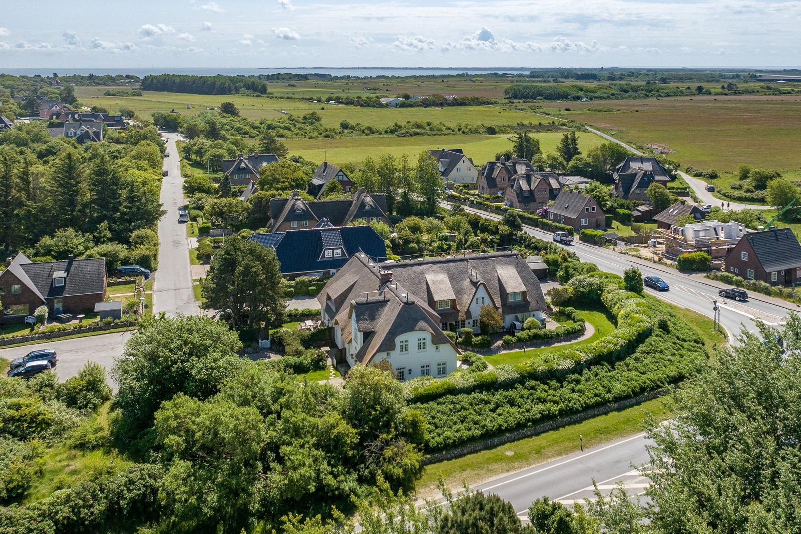 Haus mit Dachstuhl und Garten in ländlicher Umgebung mit Straßen und Feldern.