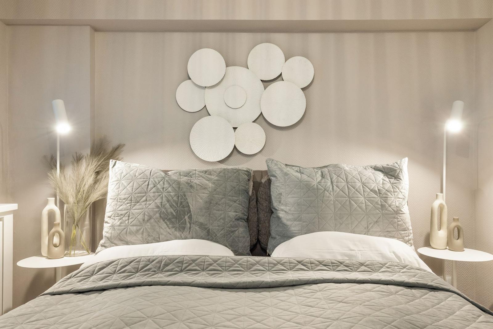 Schlafzimmer mit Bett, Kissen und Wanddekoration