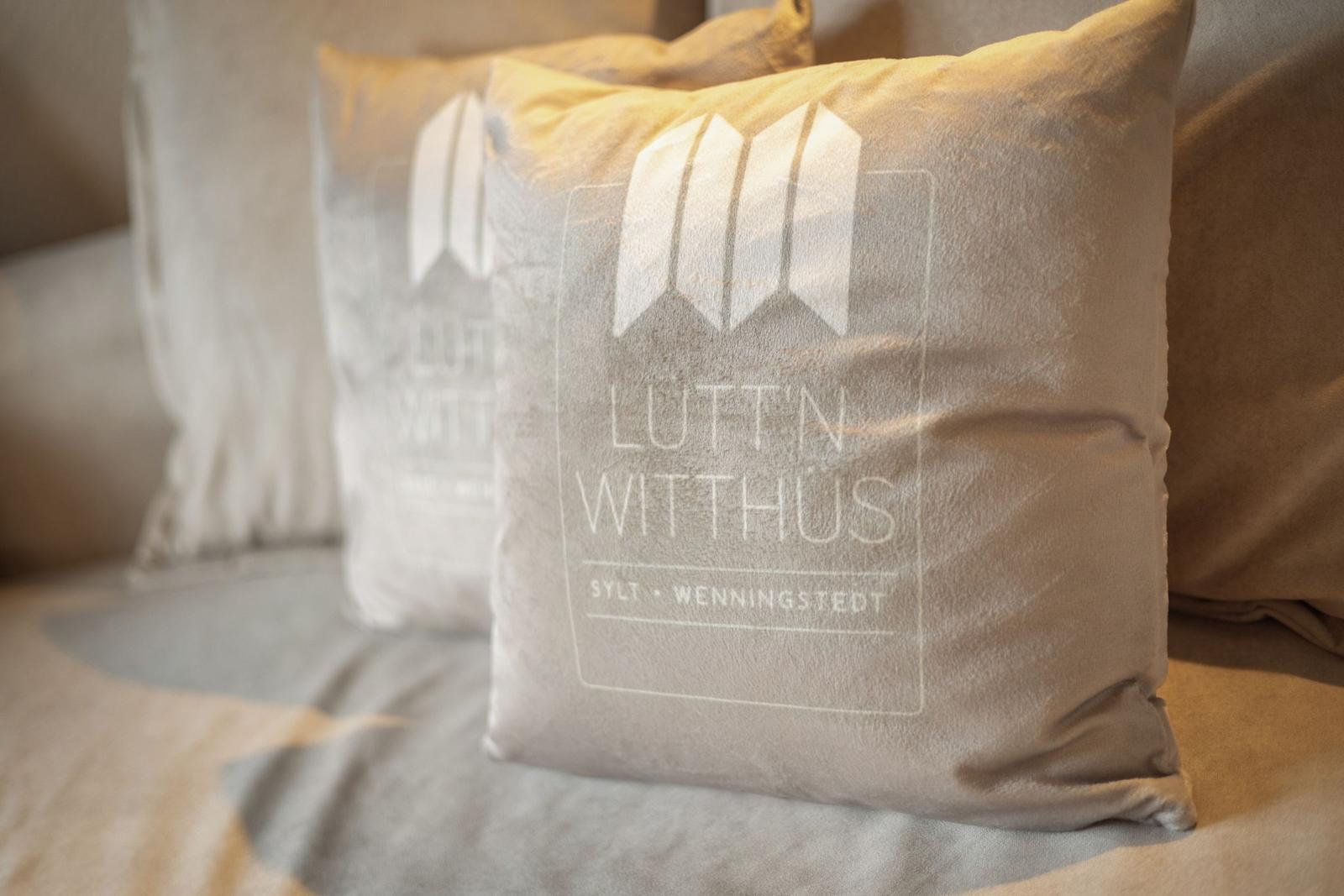 Kissen mit Logo auf Sofa in Wohnraum