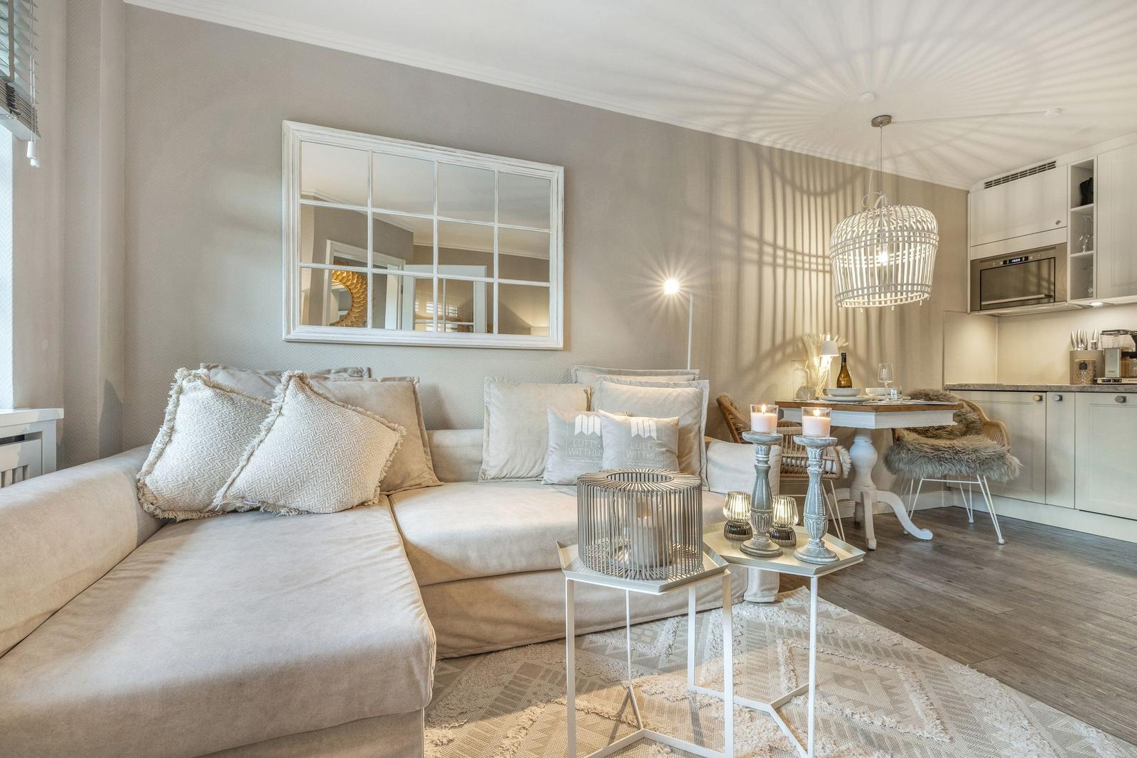 Wohnzimmer mit Sofa, Spiegel und Essbereich