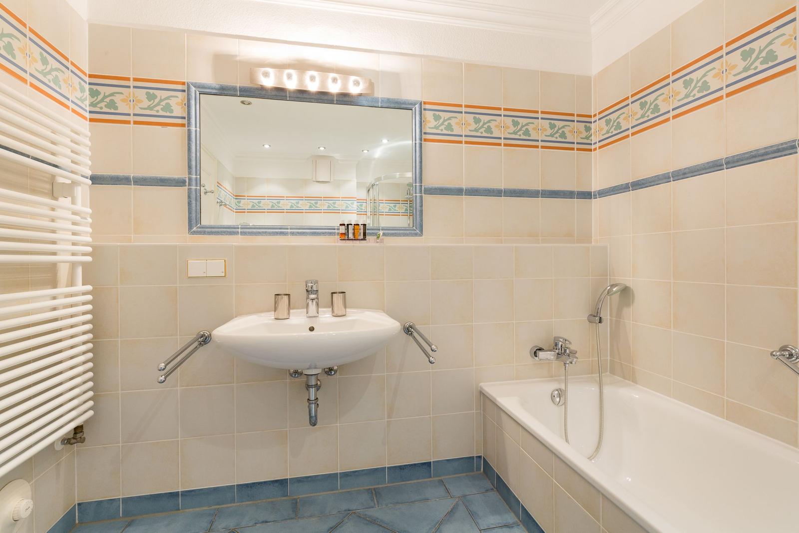 Bad mit Waschbecken, Badewanne und Spiegel