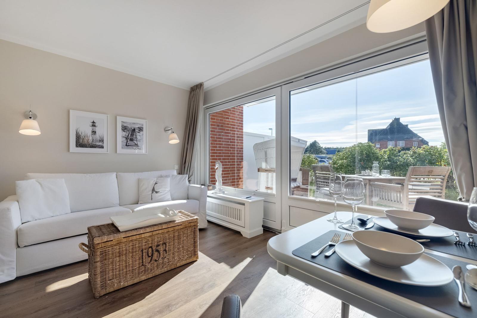 Living and dining area with view of balcony and garden.