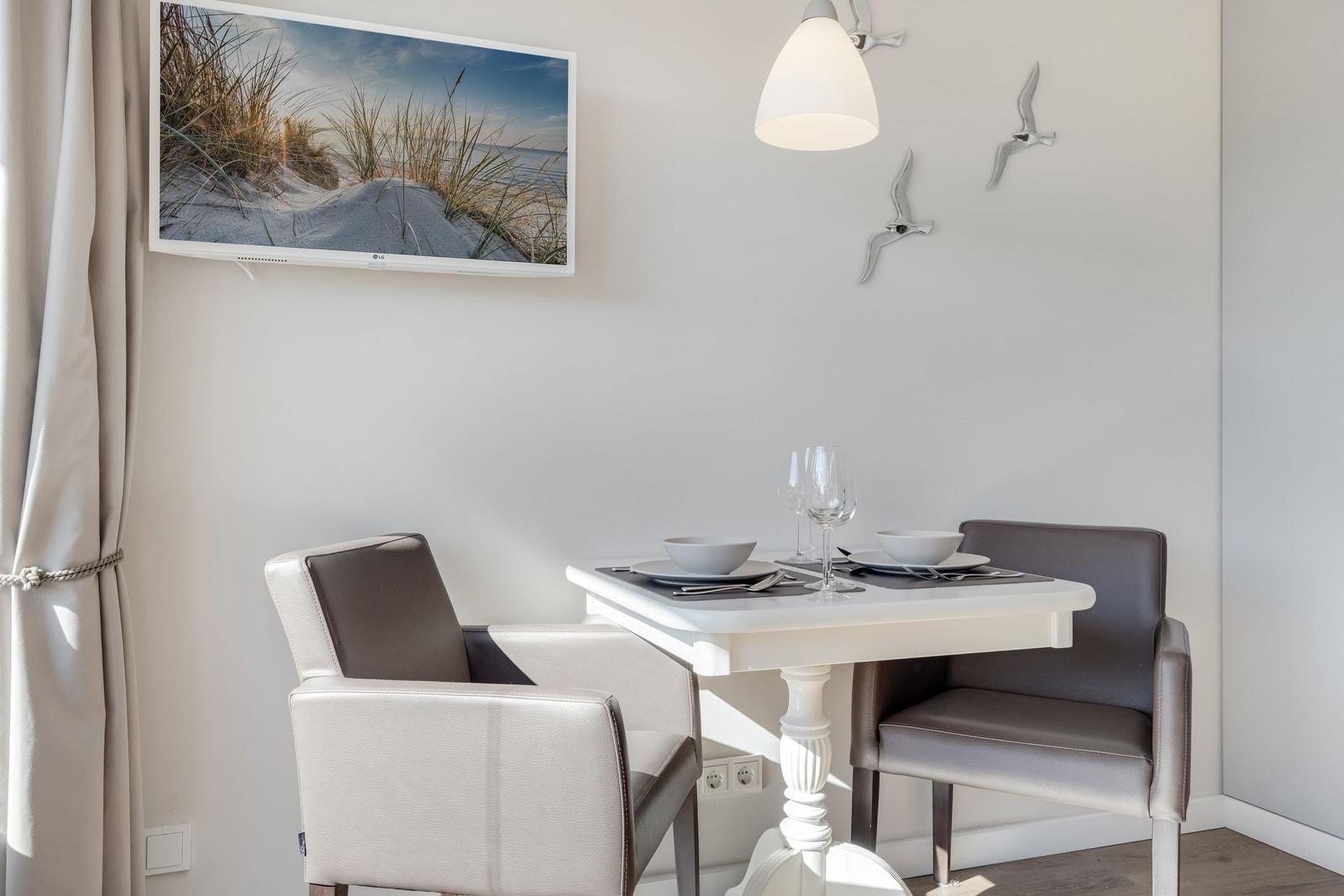 Dining table with two chairs, wall picture and wall decor