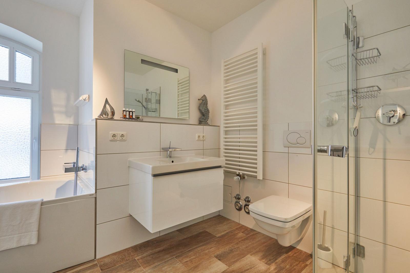 Badezimmer mit Dusche, Badewanne, Waschbecken und Toilette.
