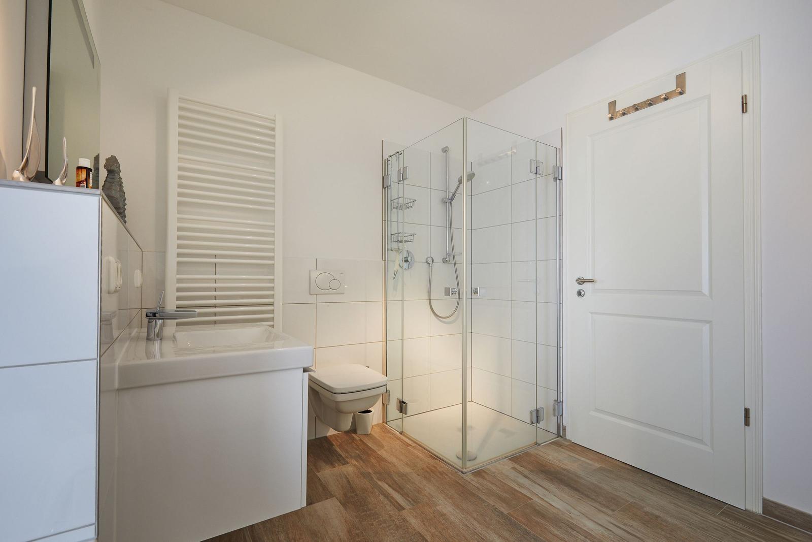 Badezimmer mit Dusche, Toilette und Waschbecken.
