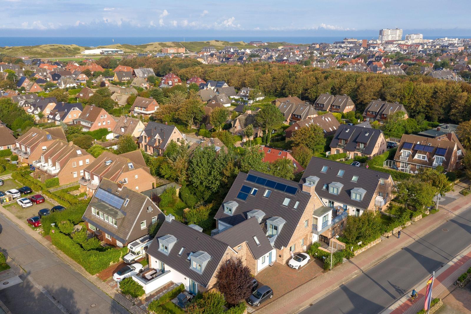 Dorf mit Häusern, Grünflächen und Blick aufs Meer