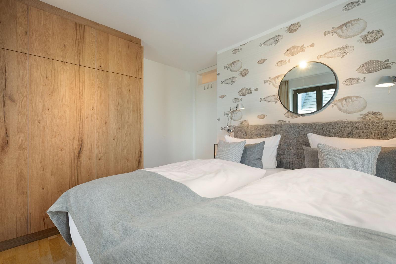 Bedroom with bed, wooden wardrobe, and fish wallpaper