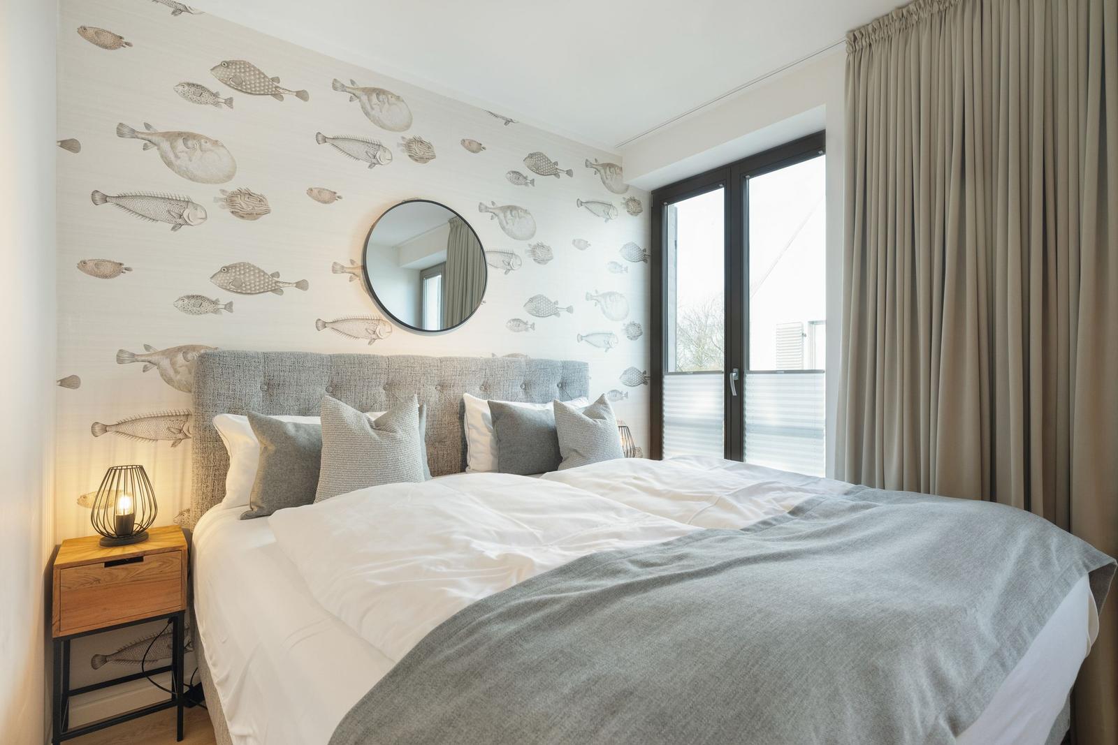 Bedroom with fish wallpaper, bed, and window