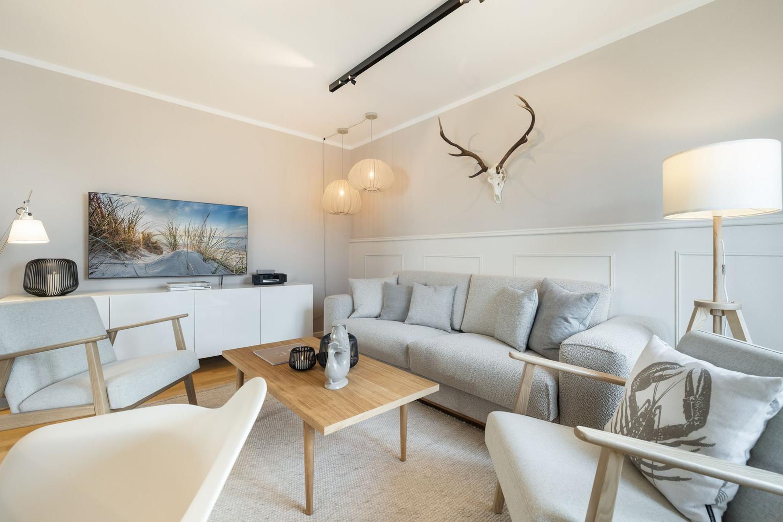 Living room with sofa, coffee table, and TV on the wall.