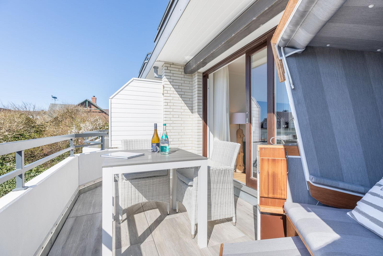 Terrace with table, chairs, and lounge. View into living area and garden.