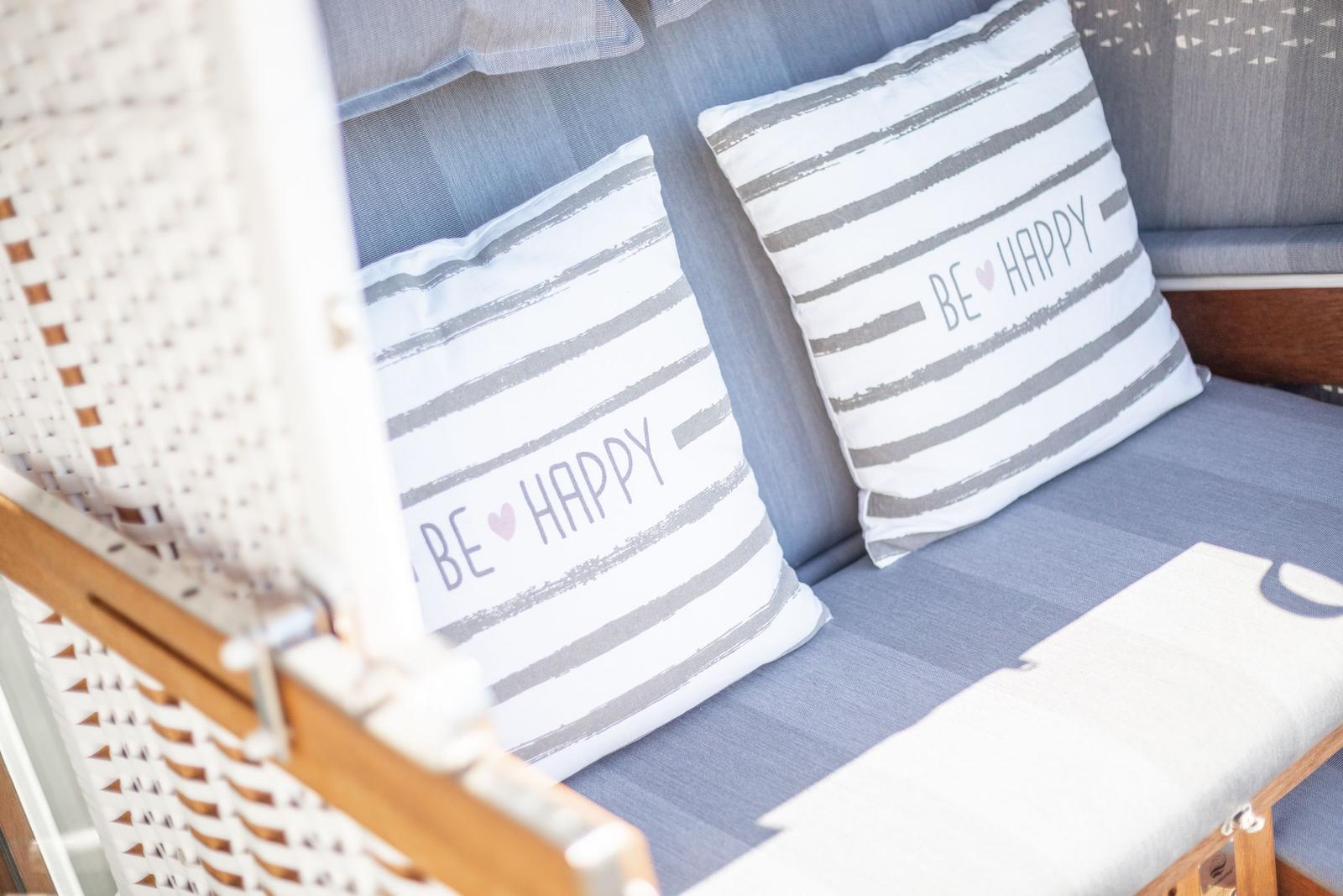 Sofa with cushions reading BE HAPPY