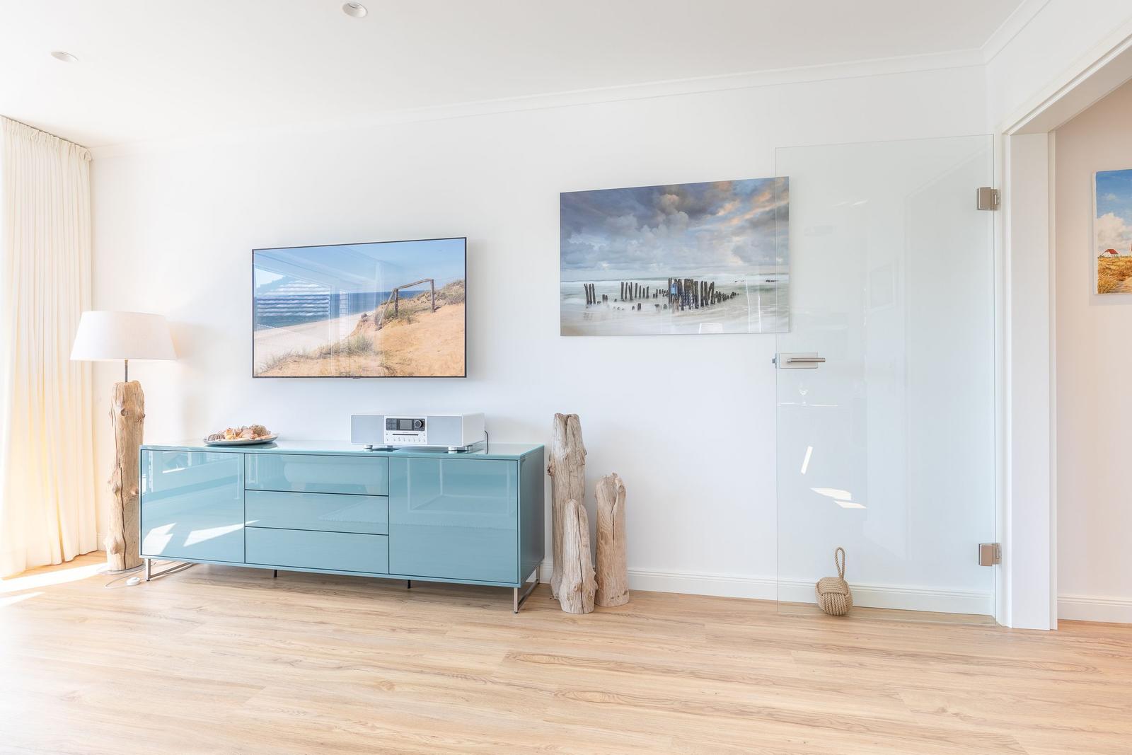 Living room with TV, media console, and glass wall