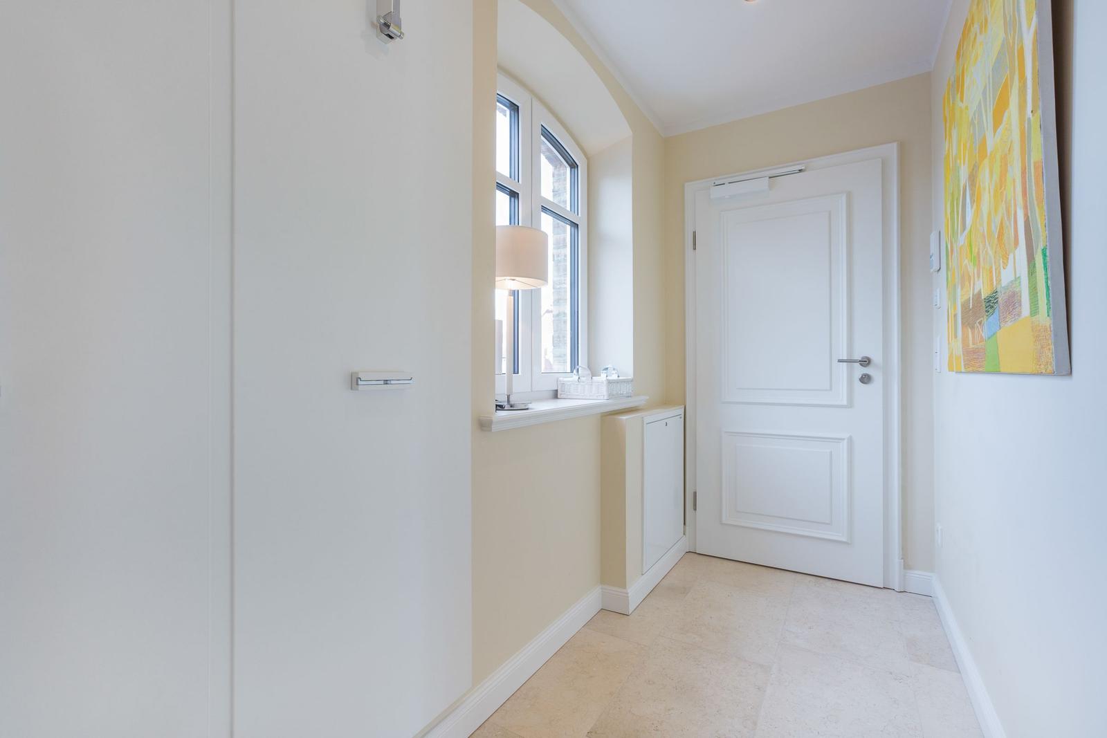 Hallenraum mit Fenster, Tür und Wandbild.