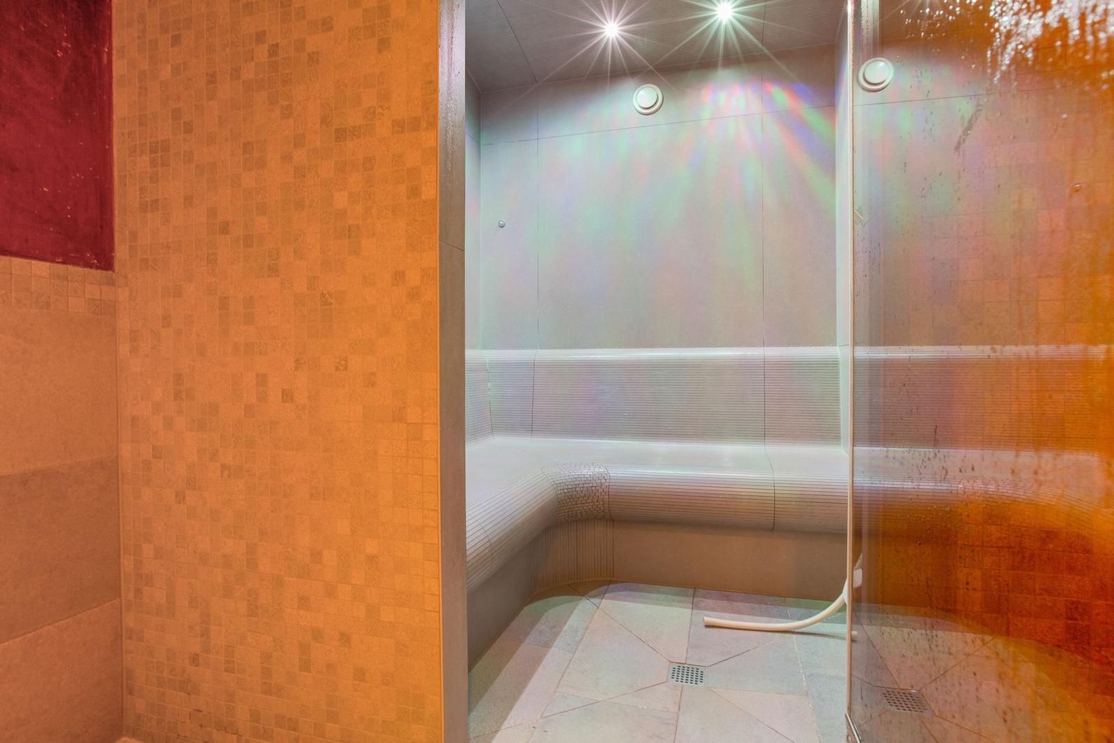 Sauna mit Sitzbank, Glaswand und Deckenbeleuchtung